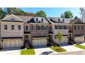 Exterior view of three-story townhomes with brick facade and two-car garages at 705 Dodd N Ln # 163, Buford, GA 30518