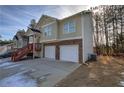 Two-story house with beige siding, two-car garage, and a red staircase at 113 Omega Ct, Dallas, GA 30157