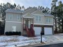 Tan two-story house with a two-car garage and red wooden stairs leading to the front entrance at 113 Omega Ct, Dallas, GA 30157