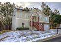 Two-story house with beige siding, two-car garage, and a red staircase at 113 Omega Ct, Dallas, GA 30157