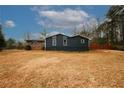 Rear view of a renovated home with gray siding at 4924 River Rd, Ellenwood, GA 30294