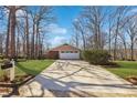 Long concrete driveway leading to a two-car garage, surrounded by landscaped yard at 3660 Hickory Se Cir, Smyrna, GA 30080