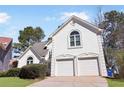 Elegant stucco home with a two-car garage, arched windows, and manicured landscaping, offering sophisticated curb appeal at 3812 Chalmers Ct, Clarkston, GA 30021