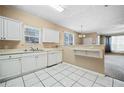 Kitchen with white cabinets, tile floor and modern appliances at 6691 Sunset Hills Blvd, Rex, GA 30273