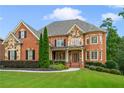 Brick two-story house with stone accents, landscaped lawn, and a three-car garage at 2832 Springbluff Ln, Buford, GA 30519