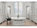 Luxurious bathroom with a freestanding tub, large windows, and elegant vanity with storage at 4874 Kettle River Pt, Suwanee, GA 30024