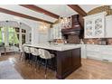 Spacious kitchen featuring an island with seating, modern appliances, and custom cabinets with exposed brick accents at 4874 Kettle River Pt, Suwanee, GA 30024