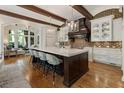 Bright kitchen featuring a large center island with marble countertop, modern pendant lighting, and brick backsplash at 4874 Kettle River Pt, Suwanee, GA 30024