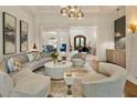 Elegant living room showcasing a curved sofa, modern lighting, and open access to other living spaces at 4874 Kettle River Pt, Suwanee, GA 30024