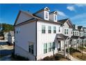 Side view of a two-story townhome showcasing white siding and a partially visible gray neighbor at 2709 Richmond Row Dr, Suwanee, GA 30024