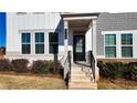 Front entryway with brick steps, black door, and mature shrubs at 2709 Richmond Row Dr, Suwanee, GA 30024