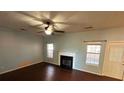 Living room with hardwood floors, fireplace, and ceiling fan at 4010 Peachtree Farms Rd, Rex, GA 30273