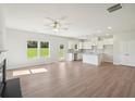Open-concept living room and kitchen boasting bright white cabinets, granite countertops, and a center island at 11831 Rizvan Pl, Covington, GA 30014