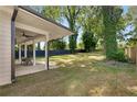 A lovely outdoor space featuring a covered patio and large backyard surrounded by mature trees and wooden fence at 199 Racine Sw St, Atlanta, GA 30314