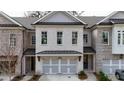 Charming brick townhome featuring a two-car garage, covered entryway, and neatly landscaped front yard at 502 Winston Croft Cir # 53, Johns Creek, GA 30022
