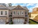 Charming brick townhome showcasing a two-car garage, covered entryway, and manicured landscaping at 502 Winston Croft Cir # 53, Johns Creek, GA 30022