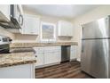 Modern kitchen with white cabinets, granite counters, and stainless steel appliances at 1603 Hollyhock Ter, Decatur, GA 30032