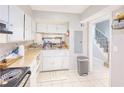 White kitchen with black appliances and view of staircase at 6036 Regent Mnr, Lithonia, GA 30058