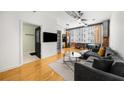 Open living area with hardwood floors, gray sectional sofa, and kitchen at 800 Peachtree Ne St # 8607, Atlanta, GA 30308