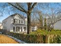 Two-story white house with a wraparound porch and landscaping. Partially visible neighboring house at 1399 Knob Hill Se Ct, Atlanta, GA 30316