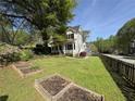 Beautifully landscaped front yard with green grass and wooden garden planters surrounding a charming two-story home at 1399 Knob Hill Se Ct, Atlanta, GA 30316