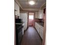 Galley kitchen featuring an oven, refrigerator, laminate counters, and white cabinets at 1643 Westhaven Sw Dr, Atlanta, GA 30311