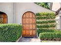 Elegant arched wood door entryway with well-manicured hedges on either side at 23 Paces West, Atlanta, GA 30327