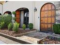 Elegant home entrance featuring a detailed arched wooden door and lush green landscaping at 23 Paces West Dr, Atlanta, GA 30327