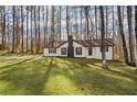 White ranch home with dark accents and a large front yard at 1443 Daniel Rd, Villa Rica, GA 30180