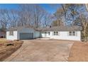 Newly renovated single-story home with a large driveway and mature trees at 1990 Old Concord Se Dr, Covington, GA 30016
