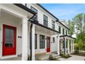 View of townhome exterior with white siding, black trim, and a bright red front door at 84 Black Gum Ln # 44, Auburn, GA 30011