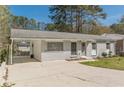 Quaint home featuring painted gray brick, a covered carport, and a tidy yard at 2649 Santa Barbara Nw Dr, Atlanta, GA 30318