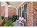 Cozy side porch featuring brick, black shutters and a cute swing for enjoying outdoor moments at 535 Cape Ivey Dr, Dacula, GA 30019