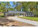Ranch style home features a gray exterior, lush lawn, and a long driveway at 1352 Jennie Sw Ln, Lilburn, GA 30047