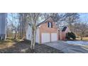 Two-car garage with side yard and trees at 1432 Cutters Mill Dr, Lithonia, GA 30058