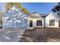 Inviting one-story house featuring a 2-car garage, tidy yard, and classic white siding at 4100 Chanticleer Nw Dr, Kennesaw, GA 30152