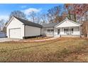 White house with attached garage and covered porch at 6045 Mockingbird Rd, Cumming, GA 30028