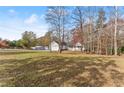 Ranch home with a large yard, trees, and a clear view at 6045 Mockingbird Rd, Cumming, GA 30028