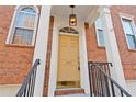 Close-up of the front entrance, featuring a classic door, house number, and elegant overhead lighting at 2428 Bridlewood Se Dr # 24, Atlanta, GA 30339