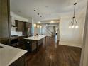 Open kitchen features an island and hardwood floors, offering views into the living area at 5981 Brundage Ln, Norcross, GA 30071