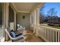 Relaxing front porch with white wicker chairs and view of trees at 820 Hedgegate Ct, Roswell, GA 30075