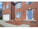 Front entrance with blue door, brick steps, and neatly maintained landscaping at 4414 Parmalee Path, Conley, GA 30288