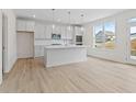 Modern kitchen with white cabinets, island, and light hardwood floors at 441 Pine Way, Dallas, GA 30157