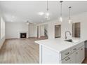 Open floor plan with kitchen island, hardwood floors, and a fireplace at 441 Pine Way, Dallas, GA 30157