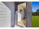 Front entryway with brick and siding, light wood floors, and a circular mirror at 237 Epping St # 89, Stockbridge, GA 30281