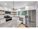 Modern kitchen featuring stainless steel appliances, granite countertops, an island, and wooden shelving at 1003 Springdale Dr, Marietta, GA 30062