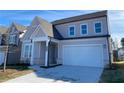 Two-story house with gray siding, white garage door, and a landscaped front yard at 4048 Annsbury Ct, Lilburn, GA 30047