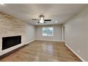 Bright living room with hardwood floors, stone fireplace, ceiling fan, and natural light from a window at 3337 Devaughn Ne Dr, Marietta, GA 30066