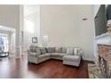 Open concept Gathering room with hardwood floors, a stone fireplace, and a large sectional sofa at 169 Blue Creek Ln, Loganville, GA 30052