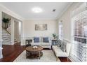 Bright living room featuring hardwood floors, a comfy sofa, and large windows at 169 Blue Creek Ln, Loganville, GA 30052